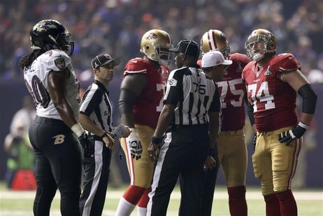 San Francisco 49ers and Baltimore Ravens players gather on the field during a power outage in the NFL Super Bowl XLVII football game in New San Francisco 49ers and Baltimore Ravens players gather on the field during a power outage in the NFL Super Bowl XLVII football game in New