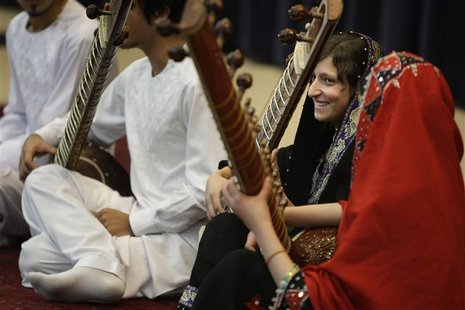A girl smiles after playing the sitar during a performance by members of the Young Afghan Traditional Ensemble at the State Department in Wa A girl smiles after playing the sitar during a performance by members of the Young Afghan Traditional Ensemble at the State Department in Wa