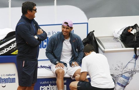 Spanish tennis player Rafael Nadal is assisted with his knee bandage as he talks to his uncle and coach Toni Nadal (L) before a training ses Spanish tennis player Rafael Nadal is assisted with his knee bandage as he talks to his uncle and coach Toni Nadal (L) before a training ses
