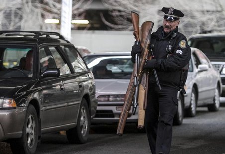 Seattle Police Department Sgt. Paul Gracy carries weapons during a gun buyback event in Seattle, Washington January 26, 2013. REUTERS/Nick A Seattle Police Department Sgt. Paul Gracy carries weapons during a gun buyback event in Seattle, Washington January 26, 2013. REUTERS/Nick A