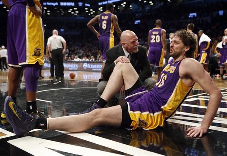 Los Angeles Lakers' Pau Gasol sits on the floor with a member of the Lakers medical staff after suffering an injury to his right leg in the Los Angeles Lakers' Pau Gasol sits on the floor with a member of the Lakers medical staff after suffering an injury to his right leg in the