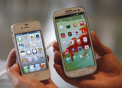 An employee holds Apple's iPhone 4s (L) and Samsung's Galaxy S III at a store in Seoul in this file photo from August 24, 2012. REUTERS/Lee An employee holds Apple's iPhone 4s (L) and Samsung's Galaxy S III at a store in Seoul in this file photo from August 24, 2012. REUTERS/Lee