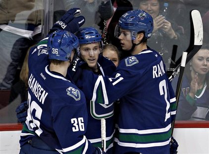 Vancouver Canucks Jordan Schroeder (C) congratulated by teammates Jannik Hansen and Mason Raymond after scoring his second goal of night aga Vancouver Canucks Jordan Schroeder (C) congratulated by teammates Jannik Hansen and Mason Raymond after scoring his second goal of night aga