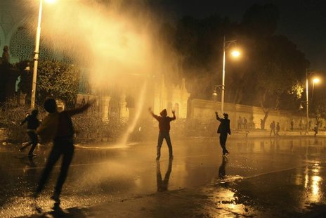 Protesters opposing Egyptian President Mohamed Mursi and the Muslim Brotherhood chant anti-government slogans while police spray water on th Protesters opposing Egyptian President Mohamed Mursi and the Muslim Brotherhood chant anti-government slogans while police spray water on th