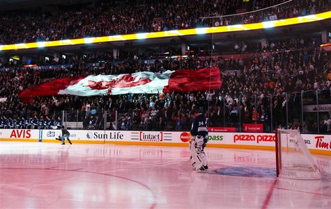 Toronto Maple Leafs goalie James Reimer stands while the Canadian national anthem is played as fans hold a giant Canadian flag before his te Toronto Maple Leafs goalie James Reimer stands while the Canadian national anthem is played as fans hold a giant Canadian flag before his te