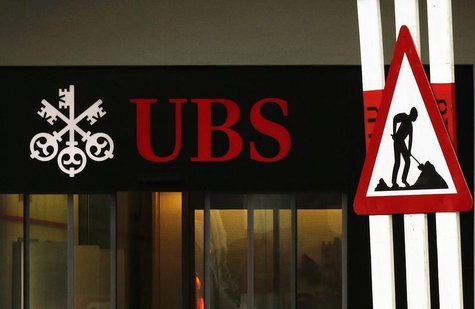 A woman woman walks past a construction road sign in front of a branch of Swiss Bank UBS in Lugano, southern Switzerland December 20, 2012. A woman woman walks past a construction road sign in front of a branch of Swiss Bank UBS in Lugano, southern Switzerland December 20, 2012.
