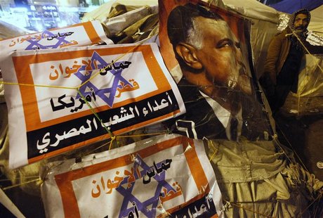 A protester opposing Egyptian President Mohamed Mursi walks outside tents near a picture of Egypt's former president Gamal Abdel Nasser duri A protester opposing Egyptian President Mohamed Mursi walks outside tents near a picture of Egypt's former president Gamal Abdel Nasser duri