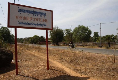A man rides a motorcycle past a signboard for the Cambodia Iron Group at the Rovieng District in Preah Vihear province February 10, 2013. RE A man rides a motorcycle past a signboard for the Cambodia Iron Group at the Rovieng District in Preah Vihear province February 10, 2013. RE