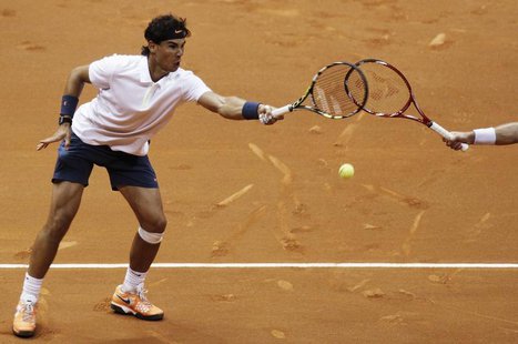 Rafael Nadal (L) of Spain hits a return next to David Nalbandian of Argentina during their men's doubles match against Spain's Pablo Andujar Rafael Nadal (L) of Spain hits a return next to David Nalbandian of Argentina during their men's doubles match against Spain's Pablo Andujar