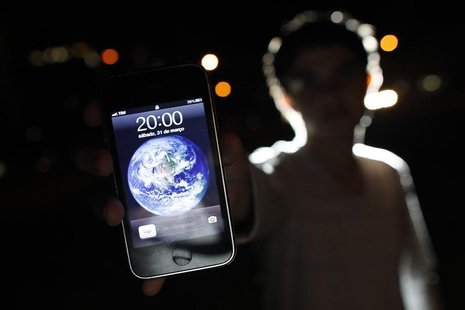 A man poses with an iPhone during Earth Hour in the center of Brasilia March 31, 2012. REUTERS/Ueslei Marcelino A man poses with an iPhone during Earth Hour in the center of Brasilia March 31, 2012. REUTERS/Ueslei Marcelino