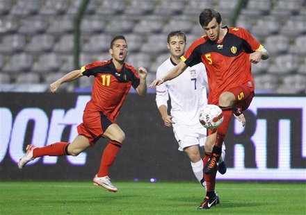 Robbie Rogers (C) of the U.S. fights for the ball with Dries Mertens (L) and Nicolas Lombaerts (R) of Belgium during their international fri Robbie Rogers (C) of the U.S. fights for the ball with Dries Mertens (L) and Nicolas Lombaerts (R) of Belgium during their international fri
