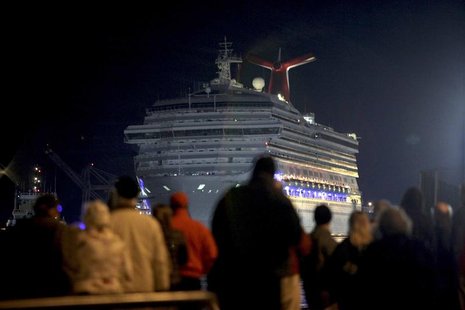 The Carnival Triumph cruise ship is towed towards the dock as spectators watch at the port of Mobile, Alabama, February 14, 2013. REUTERS/ L The Carnival Triumph cruise ship is towed towards the dock as spectators watch at the port of Mobile, Alabama, February 14, 2013. REUTERS/ L