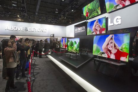 Showgoers look at a display of 55-inch OLED televisions in the LG Electronics booth during the first day of the Consumer Electronics Show (C Showgoers look at a display of 55-inch OLED televisions in the LG Electronics booth during the first day of the Consumer Electronics Show (C