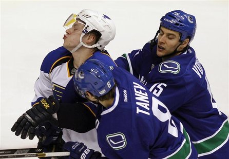 St. Louis Blues Vladimir Tarasenko (L) is checked by Vancouver Canucks Chris Tanev and Aaron Volpatti (R) during the second period of their St. Louis Blues Vladimir Tarasenko (L) is checked by Vancouver Canucks Chris Tanev and Aaron Volpatti (R) during the second period of their