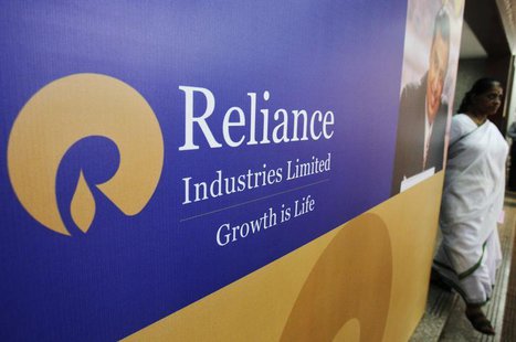A woman walks past a poster of Reliance Industries installed outside the venue of the company's annual general meeting in Mumbai June 7, 201 A woman walks past a poster of Reliance Industries installed outside the venue of the company's annual general meeting in Mumbai June 7, 201