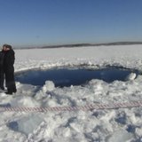 Russian police work near an ice hole, said by the Interior Ministry department for Chelyabinsk region to be the point of impact of a meteori Russian police work near an ice hole, said by the Interior Ministry department for Chelyabinsk region to be the point of impact of a meteori