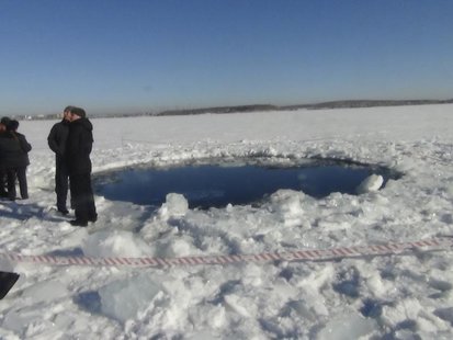 Russian police work near an ice hole, said by the Interior Ministry department for Chelyabinsk region to be the point of impact of a meteori Russian police work near an ice hole, said by the Interior Ministry department for Chelyabinsk region to be the point of impact of a meteori
