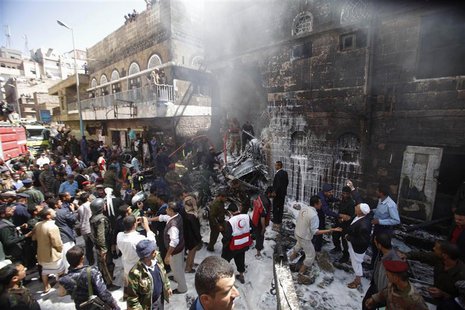 Military personnel and fire fighters try to extinguish a fire at the site of an aircraft crash in Sanaa February 19, 2013. A Yemeni fighter Military personnel and fire fighters try to extinguish a fire at the site of an aircraft crash in Sanaa February 19, 2013. A Yemeni fighter