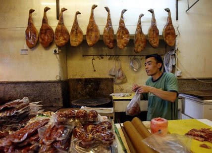 A man works in his shop selling pork products in Shanghai September 28, 2007. REUTERS/David Gray A man works in his shop selling pork products in Shanghai September 28, 2007. REUTERS/David Gray