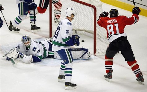 Chicago Blackhawks' Marian Hossa (R) celebrates his goal on Vancouver Canucks' Cory Schneider (L) as Canucks' Henrik Sedin looks on during t Chicago Blackhawks' Marian Hossa (R) celebrates his goal on Vancouver Canucks' Cory Schneider (L) as Canucks' Henrik Sedin looks on during t