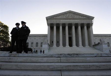 Police officers stand on the front steps on the first day of legal arguments over the Patient Protection and Affordable Care Act at the Supr Police officers stand on the front steps on the first day of legal arguments over the Patient Protection and Affordable Care Act at the Supr