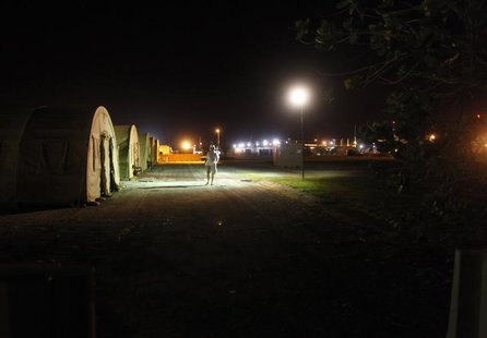 In this photo, reviewed by the U.S. military, a journalist walks past a row of tented sleeping quarters, at Camp Justice, the site of the U. In this photo, reviewed by the U.S. military, a journalist walks past a row of tented sleeping quarters, at Camp Justice, the site of the U.