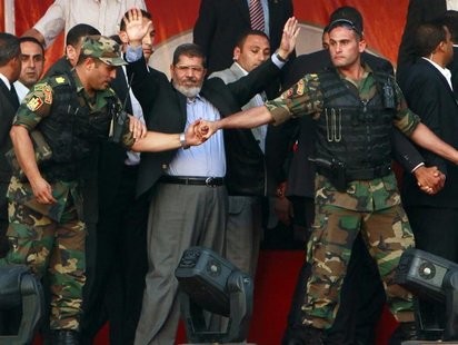 Egypt's Islamist President-elect Mohamed Mursi waves to his supporters while surrounded by his members of the presidential guard in Cairo's Egypt's Islamist President-elect Mohamed Mursi waves to his supporters while surrounded by his members of the presidential guard in Cairo's