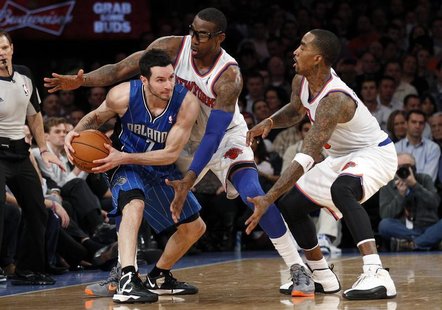 Orlando Magic's guard J.J. Redick (L) looks to pass the ball while being defended by New York Knicks' guard J.R. Smith (R) and Knicks forwar Orlando Magic's guard J.J. Redick (L) looks to pass the ball while being defended by New York Knicks' guard J.R. Smith (R) and Knicks forwar