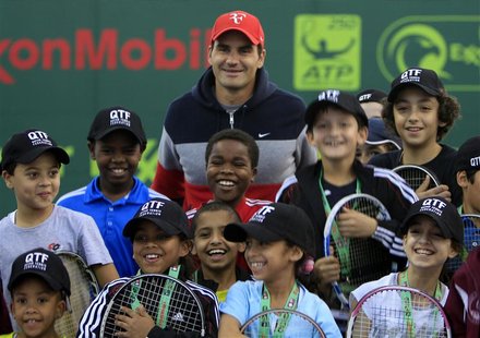 Roger Federer of Switzerland poses with the Qatari Tennis team children during the opening of the Qatar Open tennis tournament in Doha in th Roger Federer of Switzerland poses with the Qatari Tennis team children during the opening of the Qatar Open tennis tournament in Doha in th