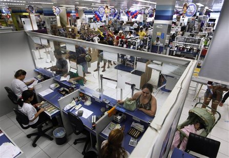 People wait in line at a branch of Bradesco bank, inside a Casas Bahia store in Sao Paulo February 18, 2013. After a spending spree in recen People wait in line at a branch of Bradesco bank, inside a Casas Bahia store in Sao Paulo February 18, 2013. After a spending spree in recen