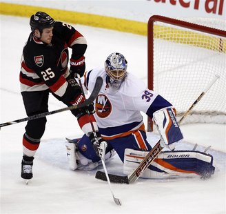 New York Islanders goalie Rick DiPietro (R) makes a save against Ottawa Senators Chris Neil during the second period of their NHL hockey gam New York Islanders goalie Rick DiPietro (R) makes a save against Ottawa Senators Chris Neil during the second period of their NHL hockey gam