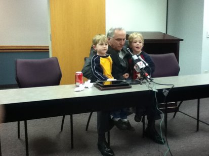 Sheriff Randy Hoenisch during press conference announcing retirement with 4-year-old twin sons Luke and Nathan, emphasizing his family must come first.