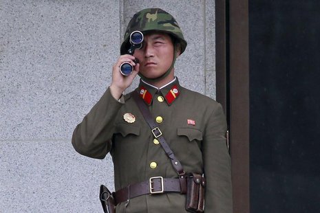 A North Korean soldier looks south through a pair of binoculars on the north side of the truce village of Panmunjom in the demilitarised zon A North Korean soldier looks south through a pair of binoculars on the north side of the truce village of Panmunjom in the demilitarised zon