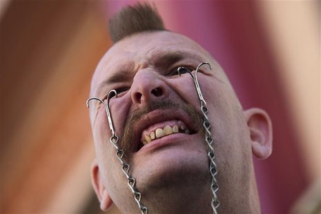 Performance artist George the Giant attaches hooks into his eyelids to hold a soda bottle ahead of the sixth annual World Sword Swallower's Performance artist George the Giant attaches hooks into his eyelids to hold a soda bottle ahead of the sixth annual World Sword Swallower's