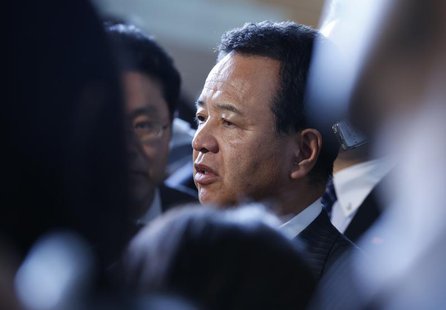 Japan's Economics Minister Akira Amari (C) is surrounded by media after a meeting with business leaders at Japan's Prime Minister Shinzo Abe Japan's Economics Minister Akira Amari (C) is surrounded by media after a meeting with business leaders at Japan's Prime Minister Shinzo Abe
