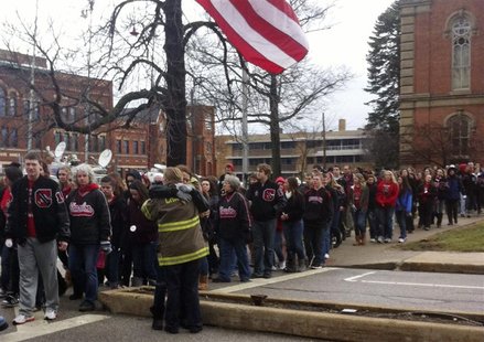 A Chardon firefighter embraces a high school student during a one year anniversary memorial march for three murdered classmates in Chardon, A Chardon firefighter embraces a high school student during a one year anniversary memorial march for three murdered classmates in Chardon,