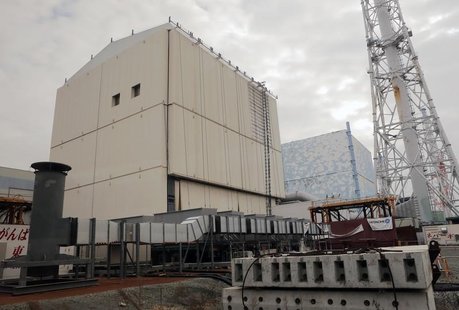 The unit No.1 (L) and No. 2 reactor building of the tsunami-crippled Fukushima Daiichi nuclear power plant are seen through a window in a bu The unit No.1 (L) and No. 2 reactor building of the tsunami-crippled Fukushima Daiichi nuclear power plant are seen through a window in a bu