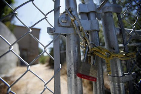 A lock secures a chain on the steel fence of a foreclosed home previously owned by U.S. Bancorp in Los Angeles, California July 17, 2012. RE A lock secures a chain on the steel fence of a foreclosed home previously owned by U.S. Bancorp in Los Angeles, California July 17, 2012. RE