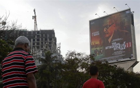 People walk underneath a promotional billboard for Ram Gopal Varma's film "The Attacks of 26/11" by a roadside in Mumbai February 28, 2013. People walk underneath a promotional billboard for Ram Gopal Varma's film "The Attacks of 26/11" by a roadside in Mumbai February 28, 2013.