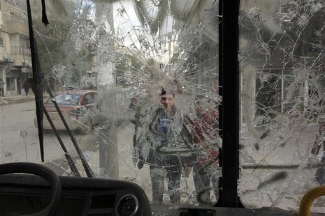 Boys are pictured through a broken windshield as they stand on a street in Aleppo February 28, 2013. REUTERS/ Giath Taha Boys are pictured through a broken windshield as they stand on a street in Aleppo February 28, 2013. REUTERS/ Giath Taha