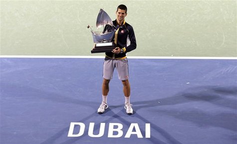 Novak Djokovic of Serbia poses with the trophy after winning his men's singles final match against Tomas Berdych of Czech Republic during th Novak Djokovic of Serbia poses with the trophy after winning his men's singles final match against Tomas Berdych of Czech Republic during th