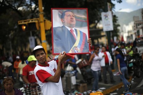 A supporter of Venezuela's President Hugo Chavez holds up a portrait of him while attending a rally in Caracas February 27, 2013. REUTERS/Jo A supporter of Venezuela's President Hugo Chavez holds up a portrait of him while attending a rally in Caracas February 27, 2013. REUTERS/Jo