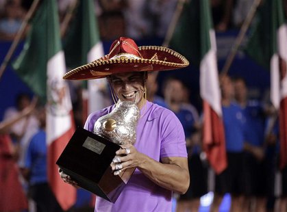 Rafael Nadal of Spain wearing a sombrero, a traditional Mexican hat, poses with his trophy after defeating compatriot David Ferrer during th Rafael Nadal of Spain wearing a sombrero, a traditional Mexican hat, poses with his trophy after defeating compatriot David Ferrer during th
