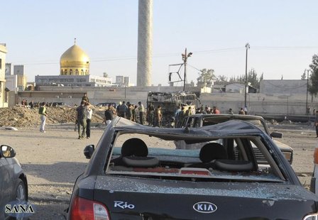 Security and residents inspect the site where a car bomb exploded in front of the gold-domed Shi'ite shrine of Sayyida Zeinab in southern Da Security and residents inspect the site where a car bomb exploded in front of the gold-domed Shi'ite shrine of Sayyida Zeinab in southern Da