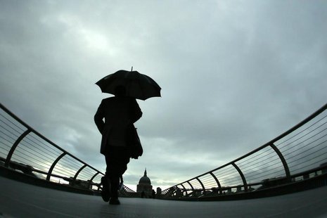 Commuters cross the Millennium Bridge during a rainy morning, towards the financial district the City of London November 27, 2012. REUTERS/S Commuters cross the Millennium Bridge during a rainy morning, towards the financial district the City of London November 27, 2012. REUTERS/S