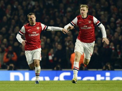 Arsenal's Lukas Podolski (L) celebrates with teammate Per Mertesacker after scoring against Bayern Munich during their Champions League socc Arsenal's Lukas Podolski (L) celebrates with teammate Per Mertesacker after scoring against Bayern Munich during their Champions League socc