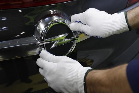 A worker adjusts an Opel logo on a vehicle at an assembly line at the Opel Gliwice factory in southern Poland February 28, 2013. REUTERS/Pet A worker adjusts an Opel logo on a vehicle at an assembly line at the Opel Gliwice factory in southern Poland February 28, 2013. REUTERS/Pet
