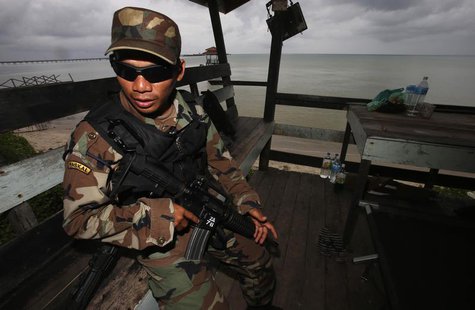 A member of the Royal Malaysian Navy's Naval Special Warfare Forces guards the beach near an area where armed men are holding off, in Felda A member of the Royal Malaysian Navy's Naval Special Warfare Forces guards the beach near an area where armed men are holding off, in Felda