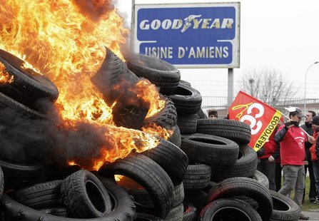 Goodyear workers burn tyres symbolizing 1,173 employees next to the Goodyear tyres factory in Amiens, February 26, 2013. REUTERS/Pascal Ross Goodyear workers burn tyres symbolizing 1,173 employees next to the Goodyear tyres factory in Amiens, February 26, 2013. REUTERS/Pascal Ross