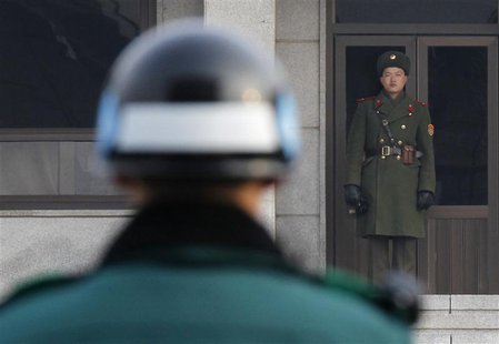 A North Korean (R) and a South Korean soldier face each other at the Panmunjom truce village in the demilitarized zone (DMZ) separating the A North Korean (R) and a South Korean soldier face each other at the Panmunjom truce village in the demilitarized zone (DMZ) separating the